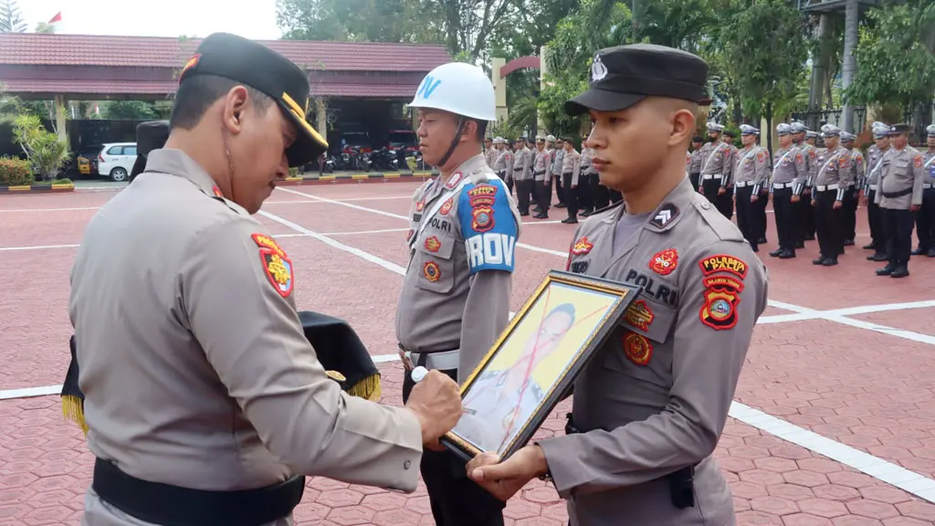 Kapolresta Palu Kombes Pol Hari Rosena mencoret foto seorang anggota polisi yang diberhentikan tidak dengan hormat di Mapolresta Palu, Senin (27/4/2026). (©Humas Polresta Palu)