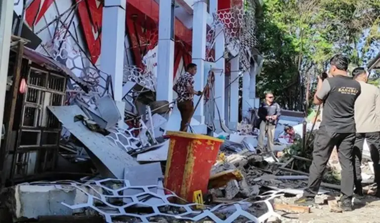Warga berada di dekat reruntuhan gedung akibat gempa 7.6 M di Manado, Kamis (2/4/2026). (©AFP/Tonny Rarung/CNN)