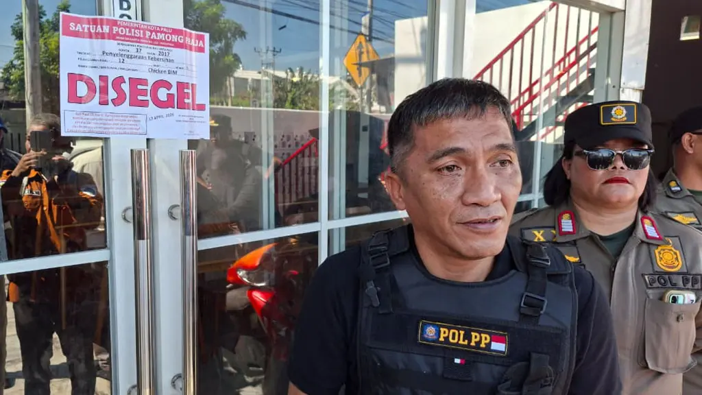 Kabid PPUD Satpol PP Kota Palu Mohamad Bambang berdiri di dekat pintu Chiken Bim Jl Basuki Rahmat Palu usai disegel, Kamis (16/4/2026). (©Prokopim Setda Kota Palu/Jufri)