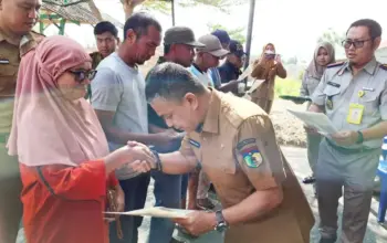 Wali Kota Palu Hadianto Rasyid menyerahkan sertifikat kepad asalah seorang warga di Huntap Balaroa, Senin (27/4/2026). (©Prokopim Setda Kota Palu/Jufri)