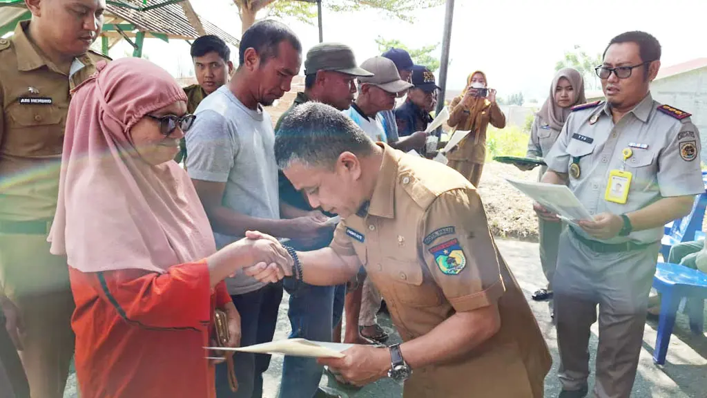 Wali Kota Palu Hadianto Rasyid menyerahkan sertifikat kepad asalah seorang warga di Huntap Balaroa, Senin (27/4/2026). (©Prokopim Setda Kota Palu/Jufri)