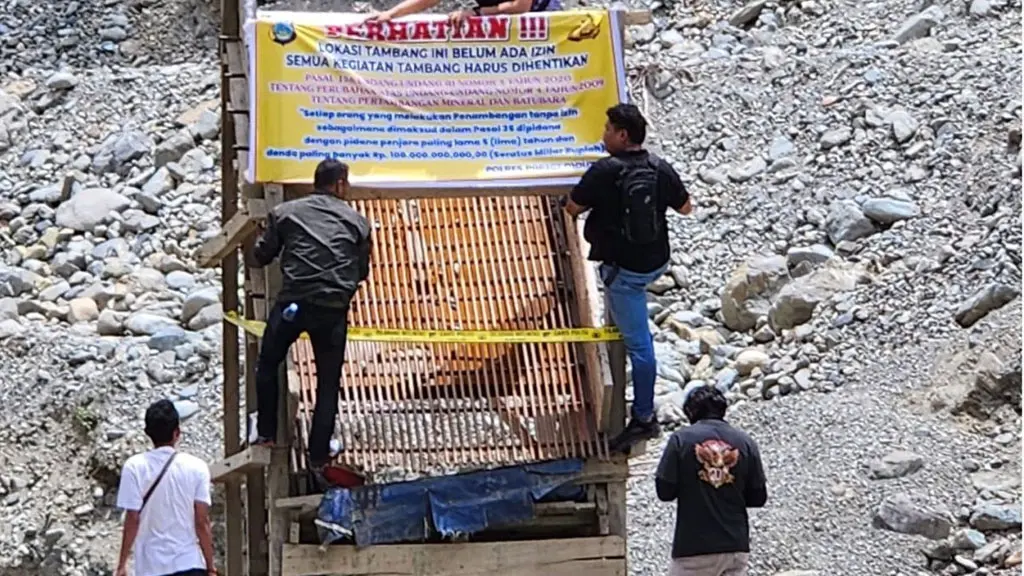 Petugas memasang spanduk peringatan usai penertiban tambang ilegal di Parigi Moutong, Sabtu (11/4/2026). (©Humas Polda Sulteng)