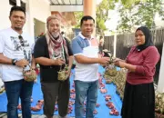 Kepala DLH Kota Palu Mohammad Arif Lamakarate (kedua kanan) bersama Sekretaris DLH Ibnu Mundzir (kedua kiri) dan Kabid Pengelolaan Sampah dan Limbah B3 DLH Hisyam Baba (kiri) menyerahkan daging kurban yang dikemas dengan Kamboti kepada warga di Kantor DLH Kota Palu, Kamis (28/5/2026). (©bmzIMAGES/Basri Marzuki)