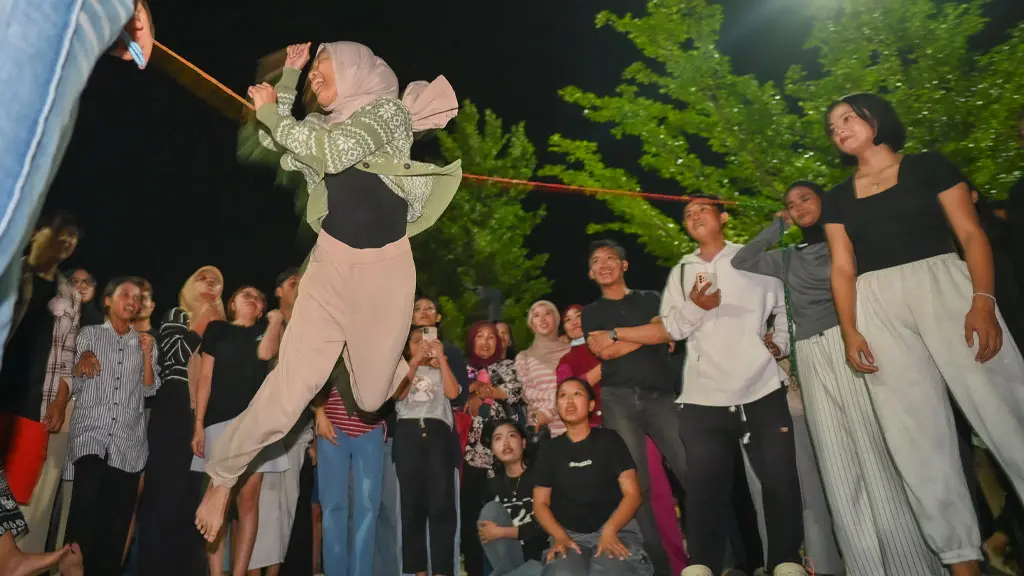 Salah seorang peserta melompati tali karet pada permainan tradisional di Lapangan Vatulemo, Palu, Jumat (22/5/2026) malam. (©bmzIMAGES/Basri Marzuki)
