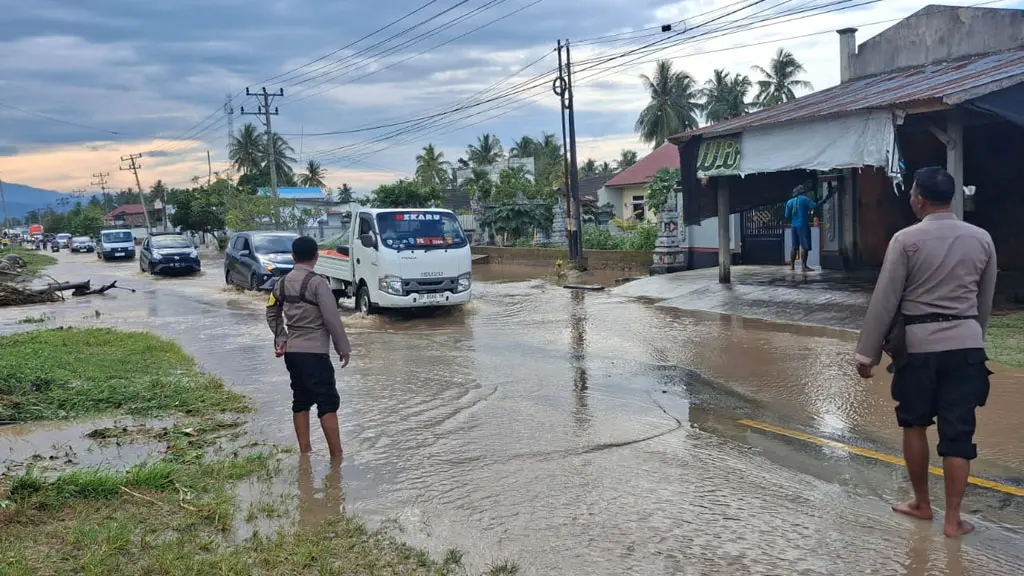 Sejumlah kendaraan menerobos banjir yang menutup jalan di Balinggi, Parimo, Senin (4/5/2026). (© Polres Parimo)