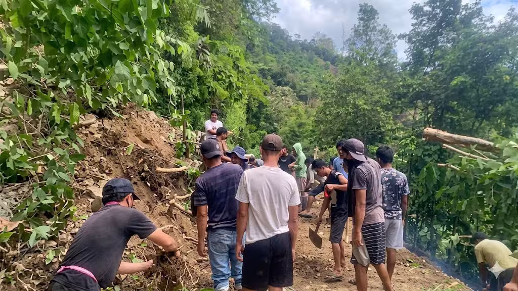 Warga bergotonh royong membersihkan jalan yang tertutup material longsor di Desa Toro, Kulawi, Sigi, Senin (25/5/2026). (©HO/BPBD Sulteng)