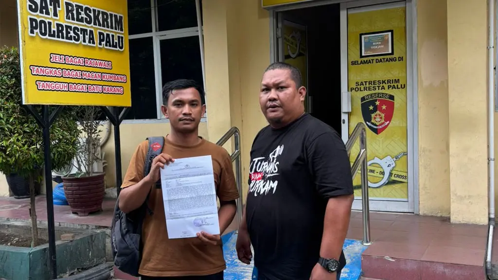 Wartawan Rian Afdhal (kiri) bersama Ketua KKJ Moh Arief usai membuat laporan polisi atas dugaan penghinaan di Mapolresta Palu, Selasa (12/5/2026). (©KKJ Sulteng)