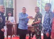 Wamen ATR/BPN Ossy Dermawan menyerahkan sertifikat kepada Kasdam XXIII/Palaka Wira Brigjen TNI Agus Sasmita di Palu, Minggu (10/5/2026). (©Pendam 23/pw)