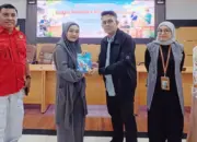 Kepala OJK Sulteng Bony Hardi Putra menyerahkan buku kepada peserta literasi keuangan di Palu. (©OJK Sulteng)