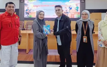 Kepala OJK Sulteng Bony Hardi Putra menyerahkan buku kepada peserta literasi keuangan di Palu. (©OJK Sulteng)