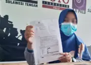 Orang tua korban menunjukkan Surat Penteapan Tersangka atas kasus pelecehan seksual atlet panahan di bawah umur di Sekretariat Rumah Jurnalis Palu, Jumat (1/5/2026). (© MAL/Ikram)