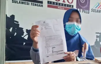 Orang tua korban menunjukkan Surat Penteapan Tersangka atas kasus pelecehan seksual atlet panahan di bawah umur di Sekretariat Rumah Jurnalis Palu, Jumat (1/5/2026). (© MAL/Ikram)