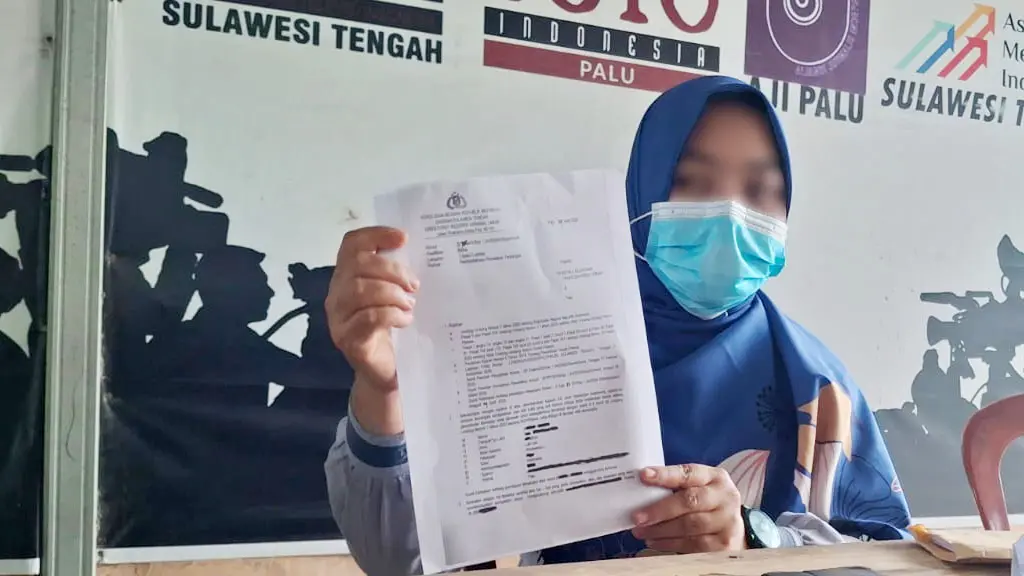 Orang tua korban menunjukkan Surat Penteapan Tersangka atas kasus pelecehan seksual atlet panahan di bawah umur di Sekretariat Rumah Jurnalis Palu, Jumat (1/5/2026). (© MAL/Ikram)
