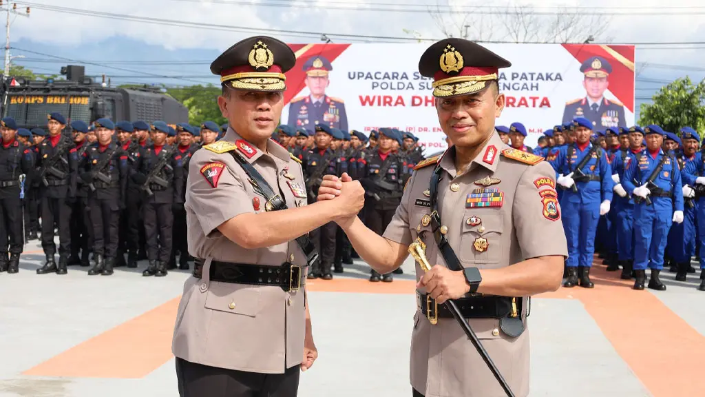 Irjen Pol (Purn) Endi Sutendi (kiri) berjabat komando dengan Kapolda Sulteng yang menggantikannya, Brihjen Pol Nasri usai upacara serah terima Pataka Wira Dharma Brata di Mapolda Sulteng, Rabu (20/5/2026). (©HUmas Polda Sulteng)