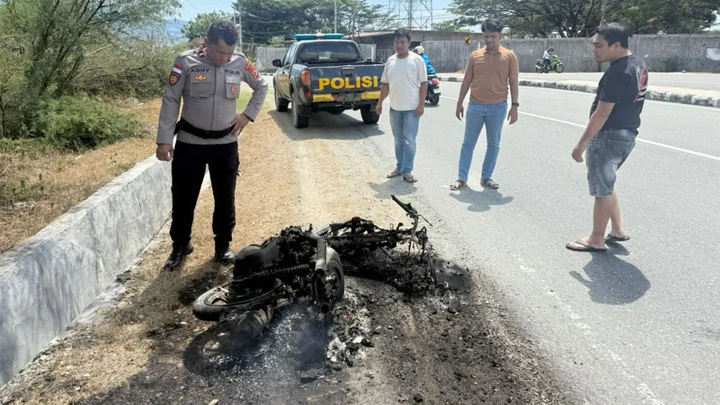 Polisi mengamati sisa-sia motor pelaku pencurian yang dibakar massa di mamboro, Selasa (12/56/2026). (©Humas Polresta Palu)