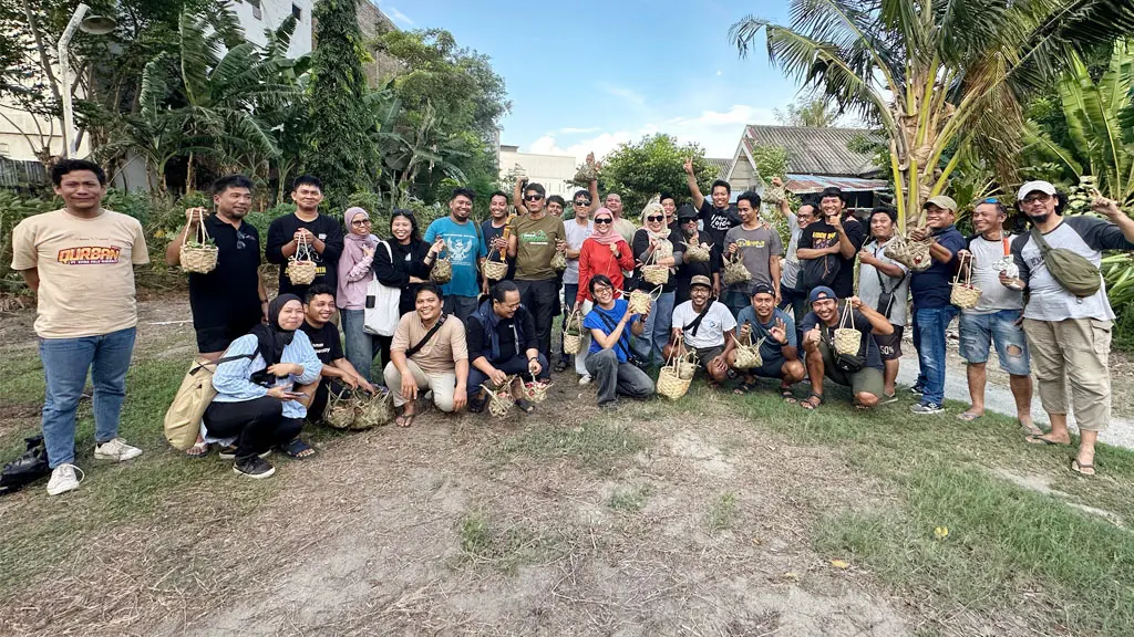 Sejumlah jurnalis yang tergabung dalam Roemah Jurnalis berofto sambil memegangi kamboti dan bingka berisi daging kurban di Palu, Kamis (28/5/2026). (©Roemah Jurnalis)