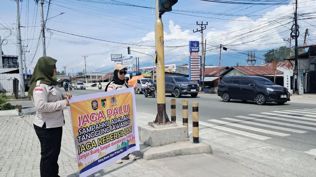 Petugas membawa spanduk imbauan kebersihan lingkungan di persimpangan jalan di Palu, Rabu (6/5/2026). (© DIskominfosantik Palu)