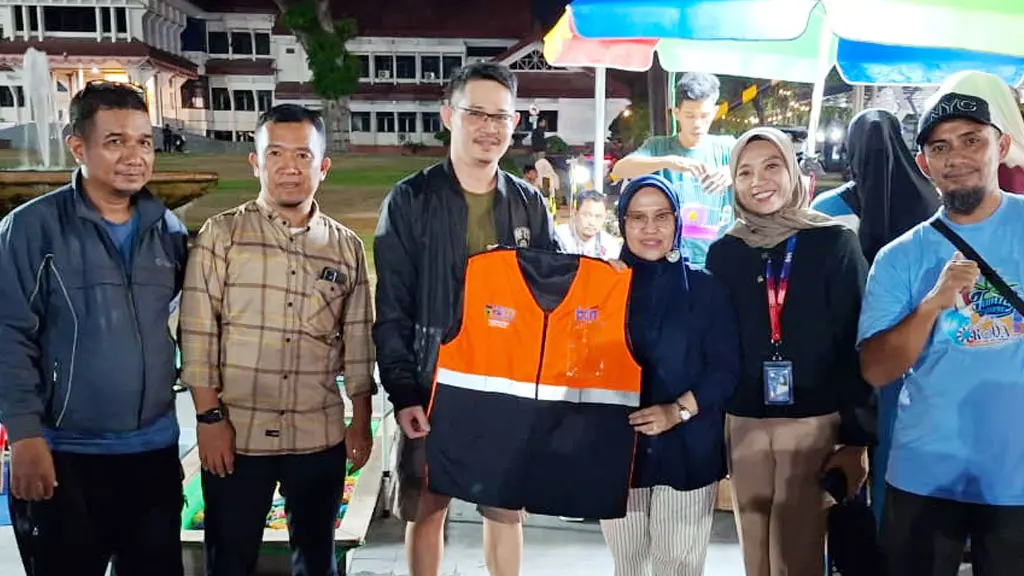 Sekot Palu Irmayanti menyerahkan rompi berkode QR kepada salah seorang pelaku UMKM di Baruga Food Strret Palu, Senin (8/6/2026). (©Prokopim Setda Kota Palu/Jufri)