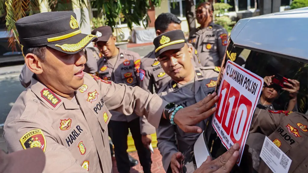 Kapolresta Palu Kombes Po Hari Rosena menempelkan stiker call center Polri 110 di kendaraan dinas Polri, Kamis (4/6/2026). (©Humas Polresta Palu)