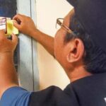 Panitia Pemutakhiran Data Pemilih menempelkan stiker tanda sudah dilakukan pencocokan dan penelitian (Coklit) pemilih di rumah warga di Kelurahan Palupi, Palu, Sulawesi Tengah, Selasa (28/2/2023). (Foto: bmzIMAGES/Basri Marzuki)