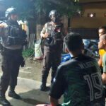 Anggota Sat Samapta Polresta Palu berbincang dengan warga saat melakukan patroli malam di kawasan pemukiman di Palu, Selasa (16/7/2024) malam. (Foto: HO-Humas Polresta Palu)