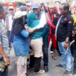 Seorang ibu memeluk bakal calon Wali Koat Palu, Hidayat dan mengadukan gerobaknya yang disita oleh pemerintah di Tmaan GOR Palu, Minggu (18/8/2024). (Foto: Tim Handal)