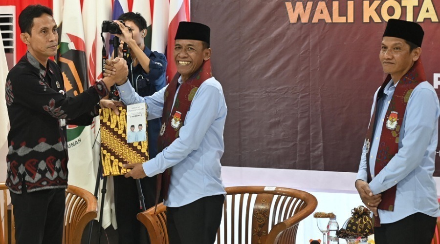 Ketua KPU Kota Palu, Idrus (kiri) menerima berkas pndaftaran bakal pasangan calon Wali Kota Palu, Hidayat (kedua kanan) dan caln Wakil Wali kota Palu, Andi Nur B Lamakarate (kanan) di Kantor KPU Kota Palu, Rabu (2/8/2024). (Foto: bmzImages/bmz)